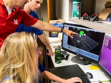 scholars and mentor studying drones