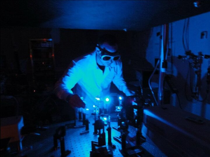 Researcher in the Uiterwaal laboratory. The frequency-tunable TOPAS laser is set to a blue wavelength to find resonances in aromatic molecules.